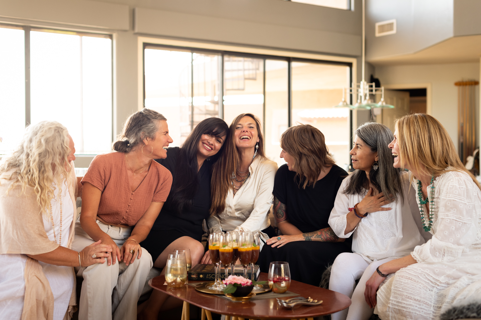A circle of women gathered together in soft afternoon light