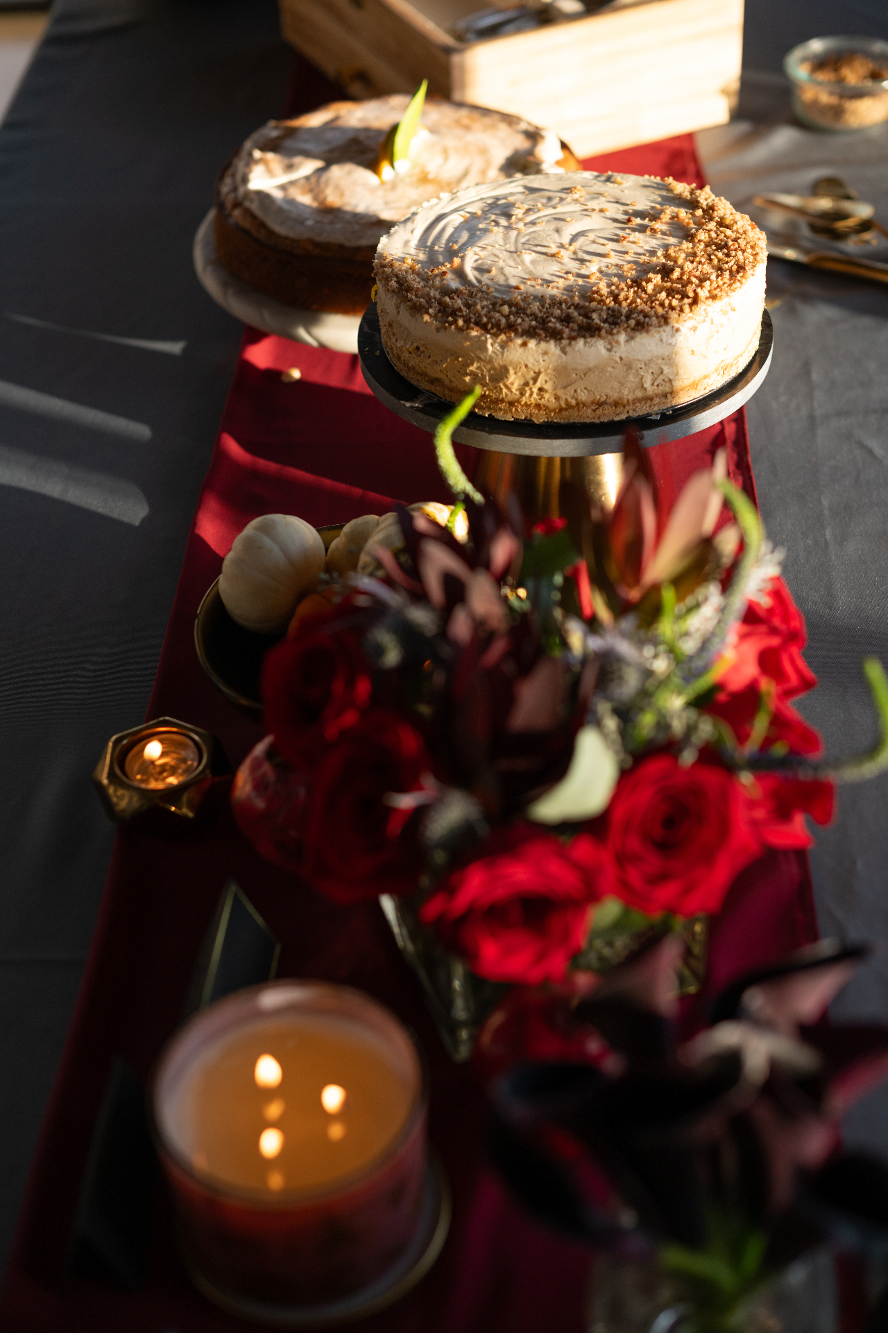 A candlelit cake table set with red roses