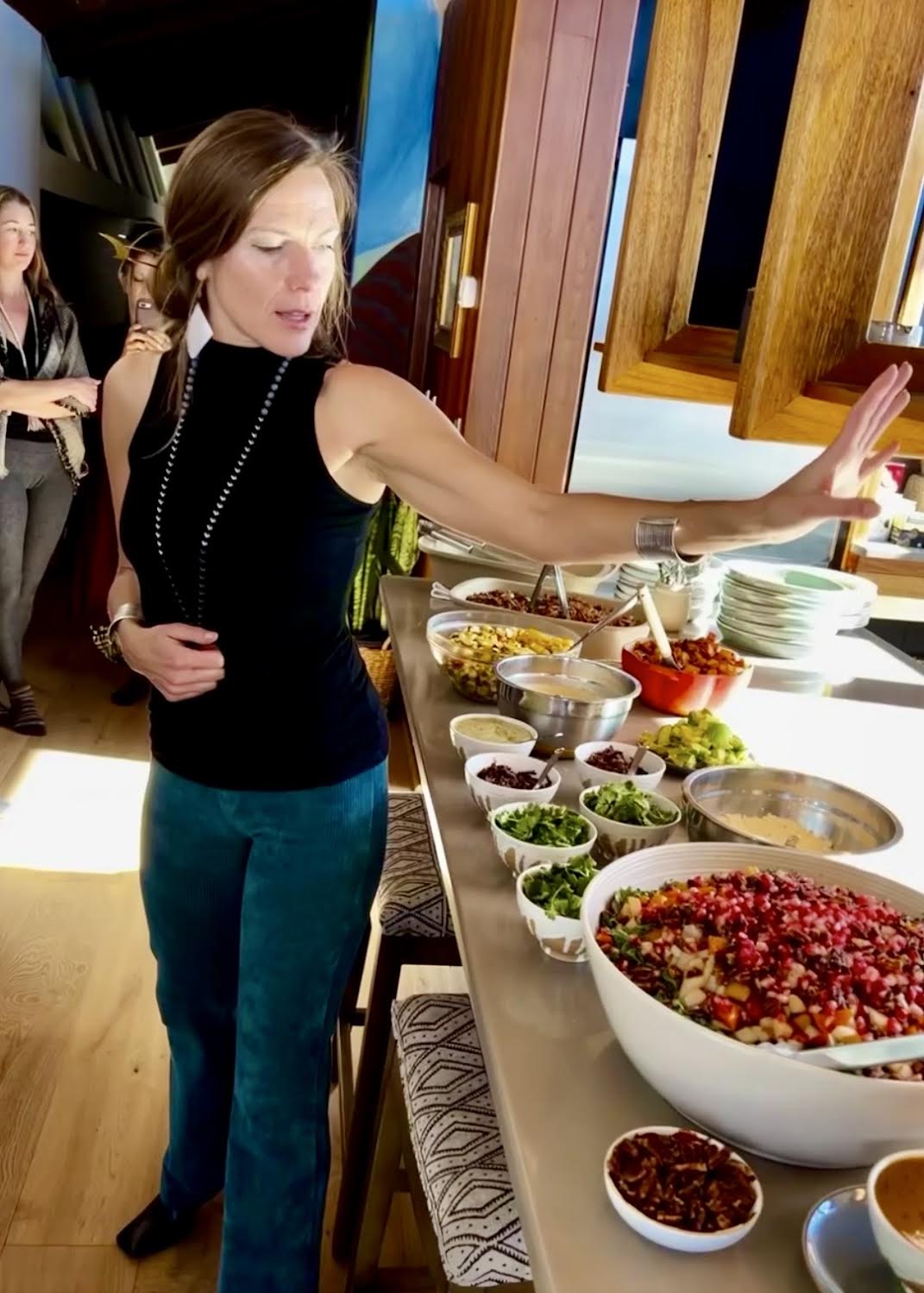 Caitlin at a long buffet table, leaning over to arrange dishes